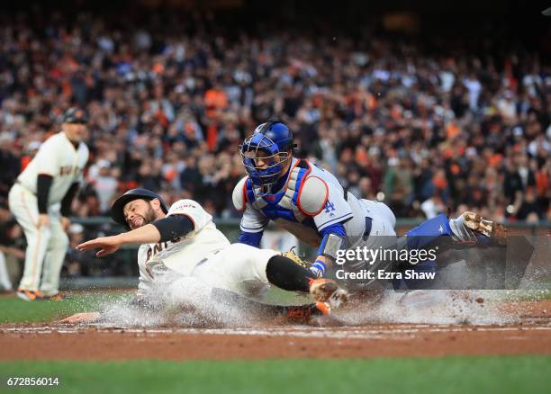Brandon Belt of the San Francisco Giants is tagged out by Yasmani Grandal of the Los Angeles Dodgers in the first inning at AT&T Park on April 24,...