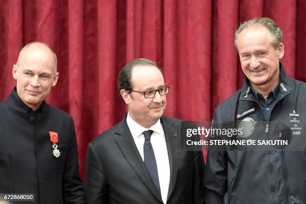 French President Francois Hollande poses with Swiss pilots of the Solar Impulse sun-powered aircraft Bertrand Piccard and Andre Borschberg during an...