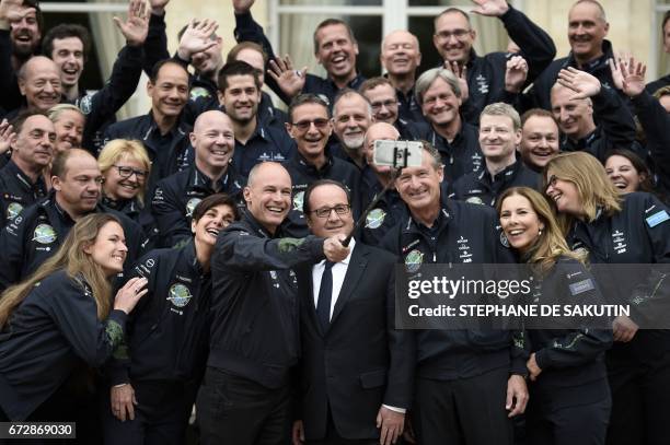 French President Francois Hollande poses for pictures with Swiss pilots of the Solar Impulse sun-powered aircraft Bertrand Piccard and Andre...