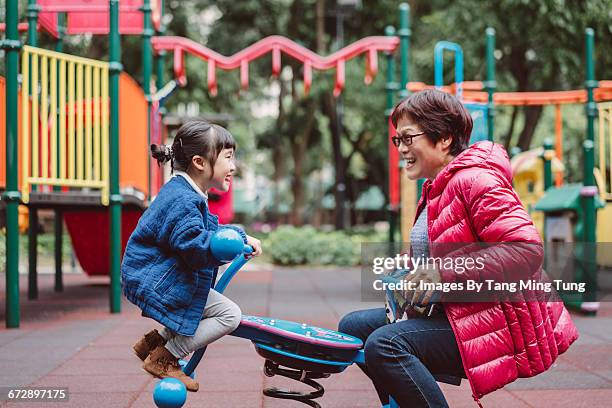 grandma playing seesaw with granddaughter - asian granny pics 個照片及圖片檔