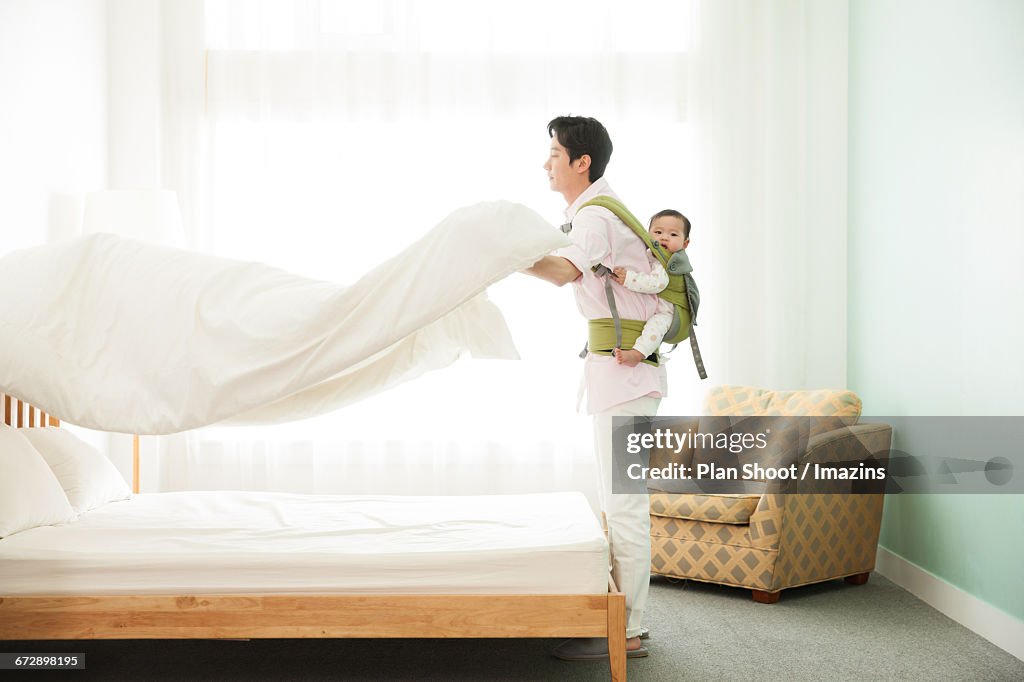 Man to housework by carrying a baby