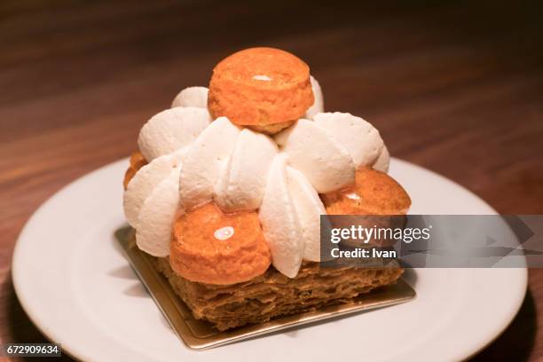 luxury french dessert, vanilla caramel puffs with napoleon slice (mille-feuille) and cream - choux pastry stock pictures, royalty-free photos & images