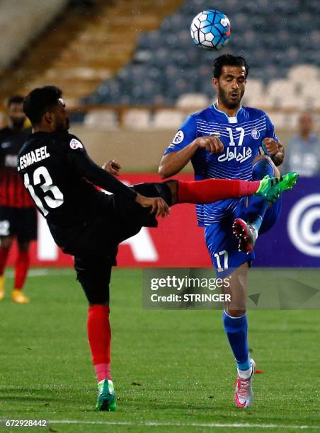 Esteghlal's Iranian forward Ali Ghorbani vies for the ball with Al-Ahli's Emirati midfielder Khamis Esmaeel during their AFC Champions League group B...