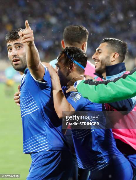 Esteghlal's Iranian forward Kaveh Rezaei celebrates with teammates after scoring his team's equalising goal during their AFC Champions League group B...