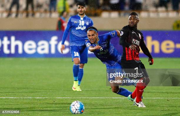 Esteghlal's Iranian midfielder Yaghoub Karimi dribbles past Al-Ahli's Emirati midfielder Ismail Al-Hammadi during their AFC Champions League group B...