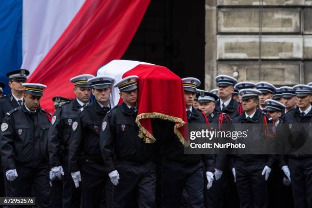 French police officers carry the flag-draped coffin during a ceremony honouring the policeman killed by a jihadist in an attack on the Champs...