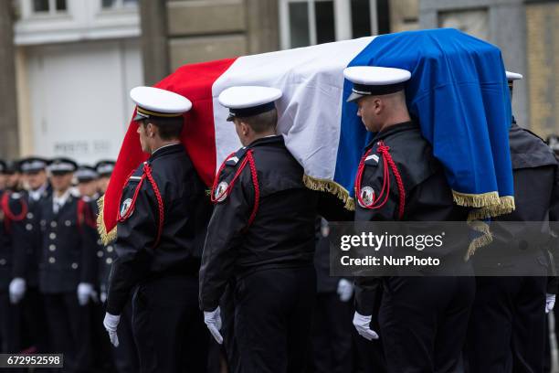 French police officers carry the flag-draped coffin during a ceremony honouring the policeman killed by a jihadist in an attack on the Champs...