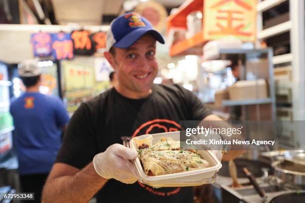 April 25, 2017 -- Brian Goldberg shows a Jianbing at the kiosk of Mr. Bing in UrbanSpace food court in New York, the United States, April 17, 2017....