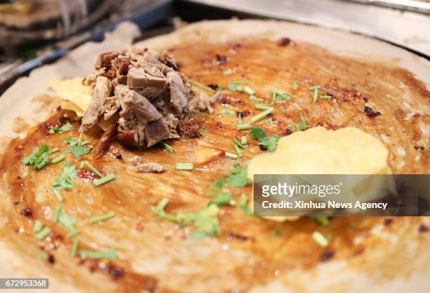 April 25, 2017 -- A Jianbing of the flavor of roasted duck is made at the kiosk of Mr. Bing in UrbanSpace food court in New York, the United States,...