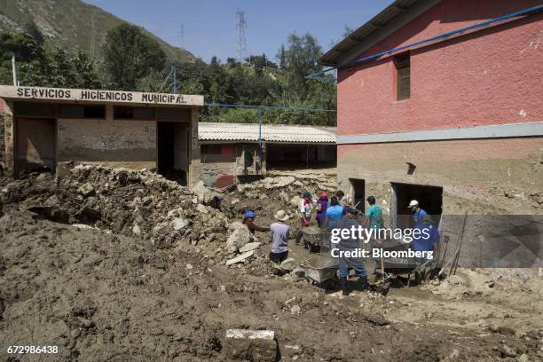 Volunteers work to rebuild homes destroyed by massive floods in the town of Barba Blanca, Huarochiri Province, in Lima, Peru, on Saturday, April 22,...