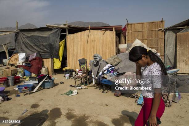 Displaced resident passes in front of tents at a temporary housing camp near the destroyed village of Cajamarquilla, Chosica district in Lima, Peru,...