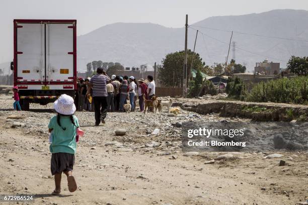 Displaced residents line up to receive groceries at a temporary housing camp near the destroyed village of Carapongo, Chosica district in Lima, Peru,...