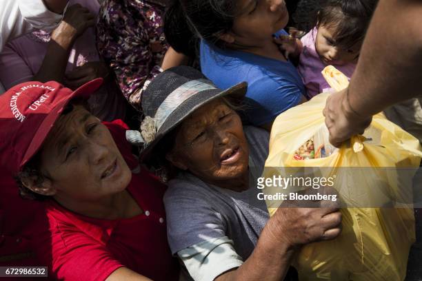 Displaced residents receive groceries at a temporary housing camp near the destroyed village of Carapongo, Chosica district in Lima, Peru, on...