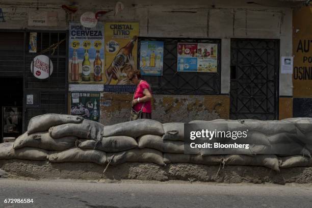 Pedestrian passes in front of sandbags outside a grocery store in the town of La Cantutua, Chosica district in Lima, Peru, on Saturday, April 22,...