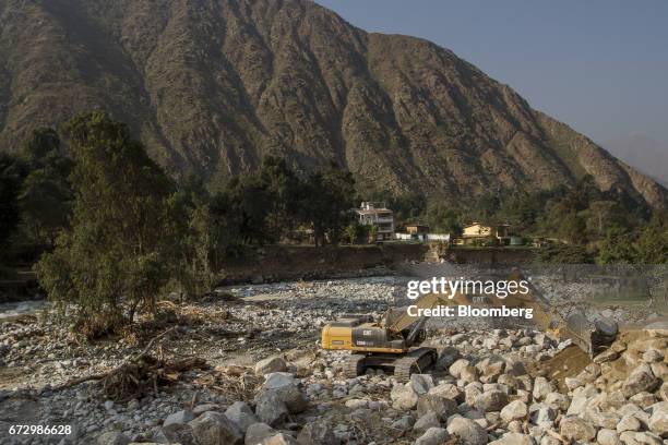 Worker operates a Caterpillar Inc. Excavator to fix a road destroyed by massive floods in the district of Santa Eulalia, Huarochiri Province, in...