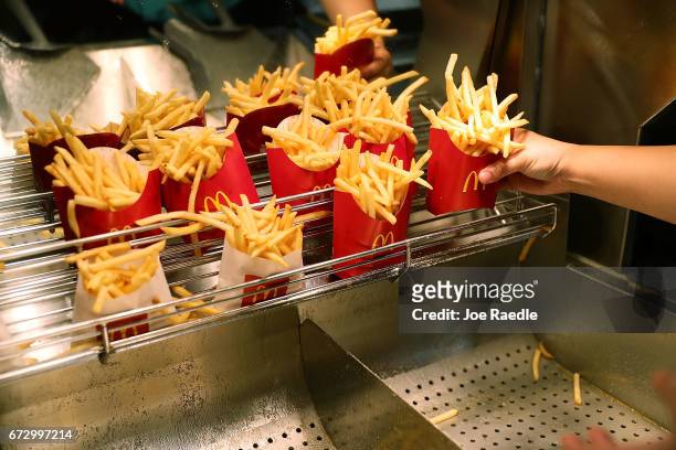McDonald's crew member Samantha Medina prepares french fries as the McDonald's restaurant stock price reached record territory on April 25, 2017 in...