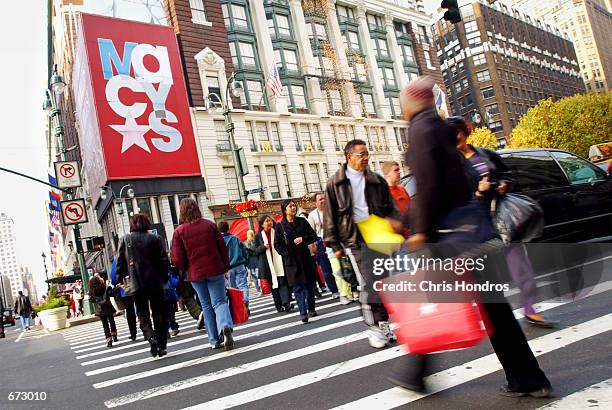 Shoppers make their way across Herald Square near Macy's department store November 23, 2001 in New York City. The Christmas shopping season started...