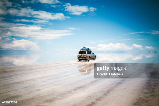 sports utility vehicle driving in the salar de uyuni - uyuni stock pictures, royalty-free photos & images