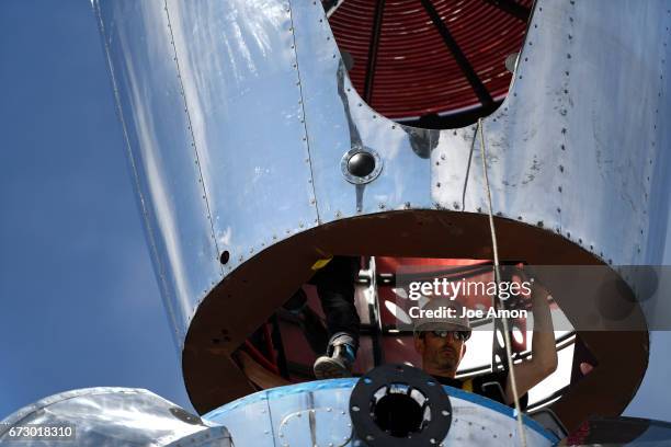 April 25: One of 3 lead artist's David Shulman guiding in the Life sciences and Bio lab section to the top of the already mounted base of the...