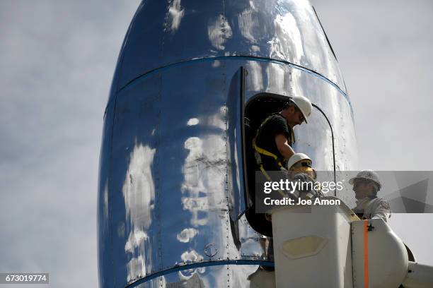 April 25: Artist David Shulman steps from the main deck after securing the topmost section of the spacecraft, the command center, as the team works...