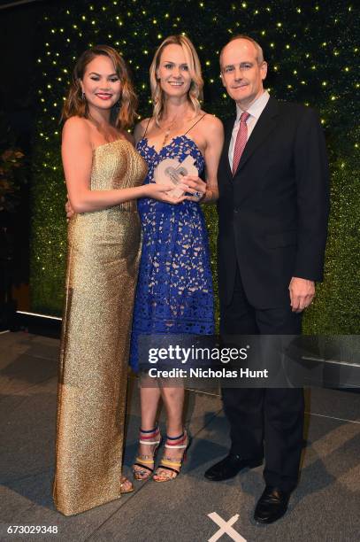 Chrissy Teigen presents an award to Lise and Michael Evans onstage at the City Harvest's 23rd Annual Evening Of Practical Magic at Cipriani 42nd...