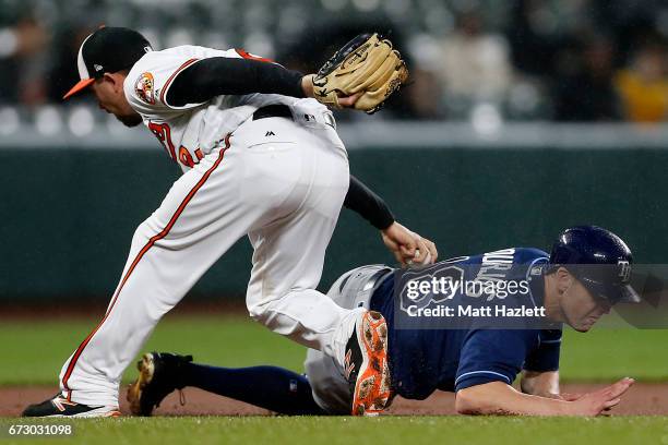 Hardy of the Baltimore Orioles tags out Peter Bourjos of the Tampa Bay Rays for the first out of the third inning at Oriole Park at Camden Yards on...