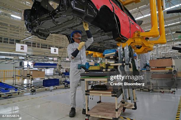 An employee assembles a Mitsubishi Motors Corp. Sports utility vehicle on a production line at the company's plant in Cikarang, Indonesia, on...