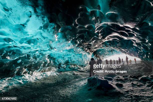 tourists in the crystal cave, breidamerkurjokull glacier, iceland - breidamerkurjokull glacier stockfoto's en -beelden