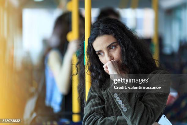pensativa, a jovem mulher viajando e segurando o telefone inteligente - autobus - fotografias e filmes do acervo