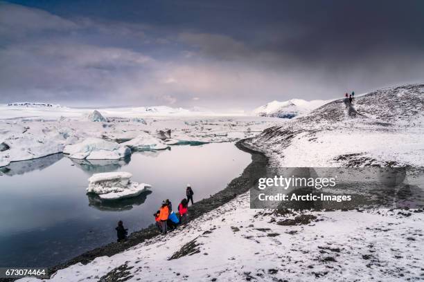 tourists, jokulsarlon glacial lagoon, iceland - icecap stock pictures, royalty-free photos & images