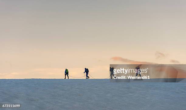 switzerland, mountaineers starting early morning from the bertol hut - four in a row stock pictures, royalty-free photos & images