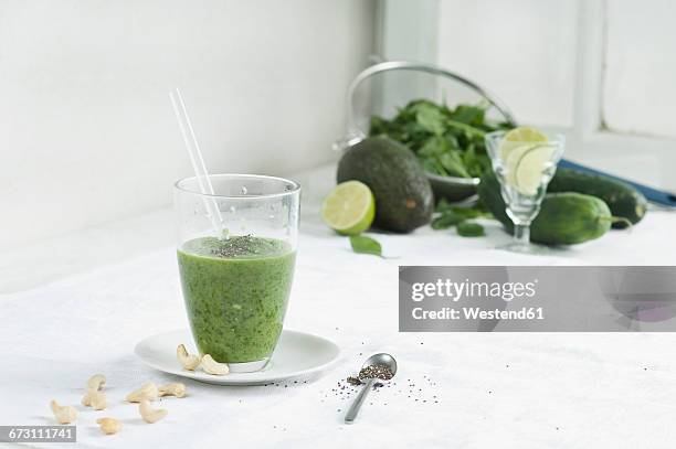 green smoothie, ingredients chia seeds, cashews, spinach, cucumber, avocado and lime - püriert stock-fotos und bilder