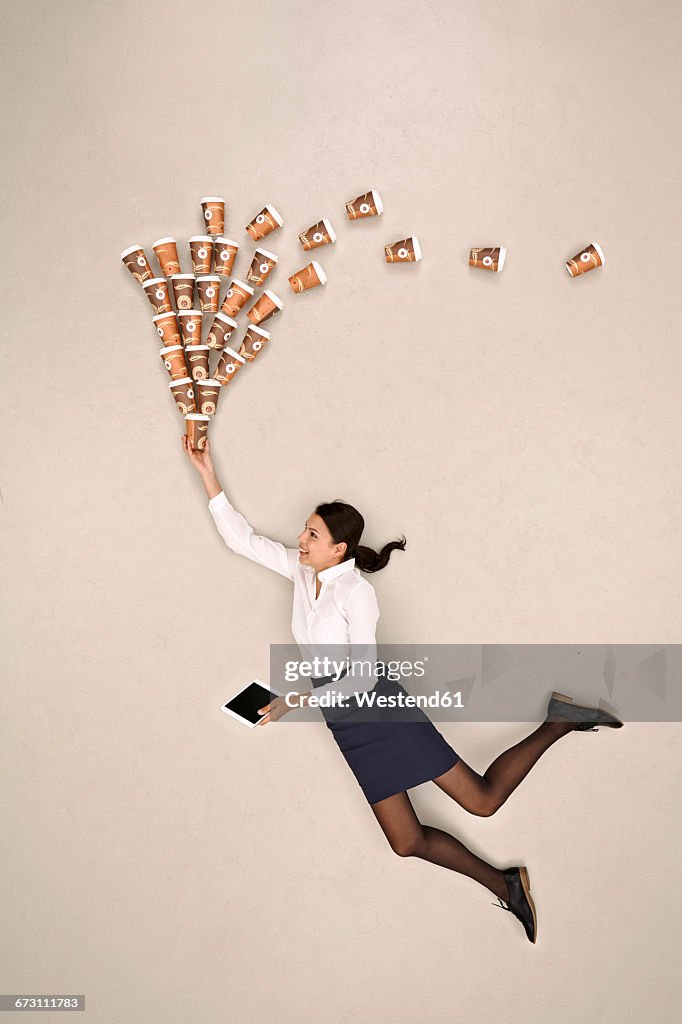 Businesswoman flying with coffee and tablet