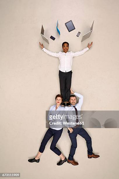 two business people carrying colleague juggling mobile devices - surrounding support stock pictures, royalty-free photos & images