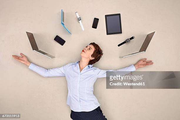 businesswoman juggling mobile devices - multitasking stock-fotos und bilder
