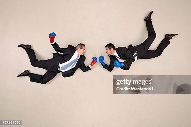 two flying businessmen boxing - boxing glove stock pictures, royalty-free photos & images