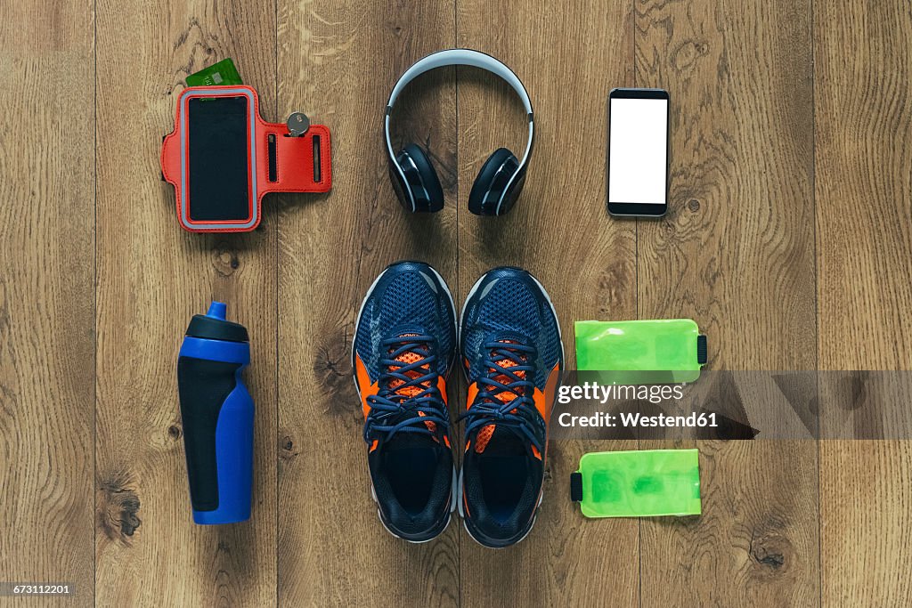 Running shoes, headphones, drinking bottle, smartphone and bags