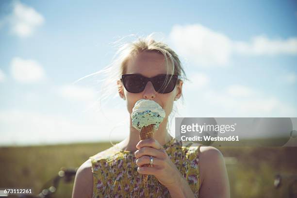 blond woman with sunglasses eating ice cream - frau eistüte stock-fotos und bilder