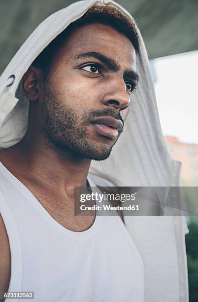 portrait of young man wearing hooded jacket - nordafrikanischer abstammung stock-fotos und bilder