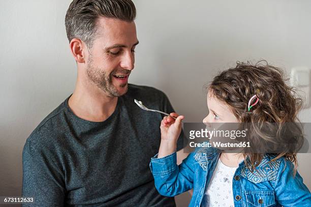 daughter feeding father - role reversal stock-fotos und bilder