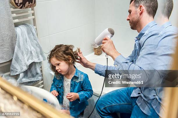 father blow-drying daughter's hair - bath girl stockfoto's en -beelden