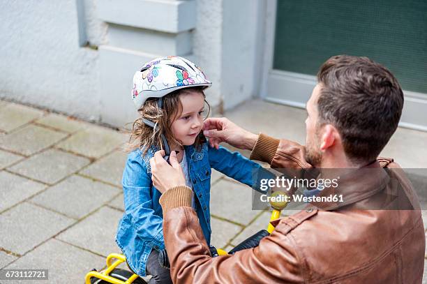 father and daughter with bicycle helmet - protection helmet stock-fotos und bilder