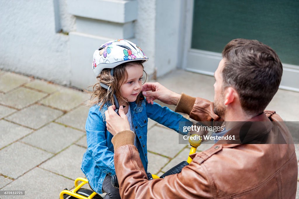 Father and daughter with bicycle helmet