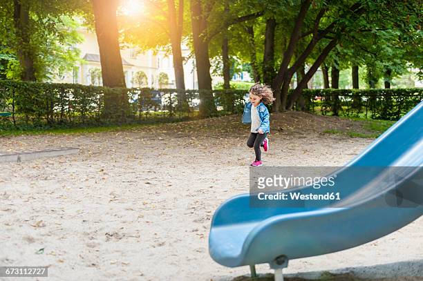 girl running on playground - 1 kid 1 sandbox stock-fotos und bilder