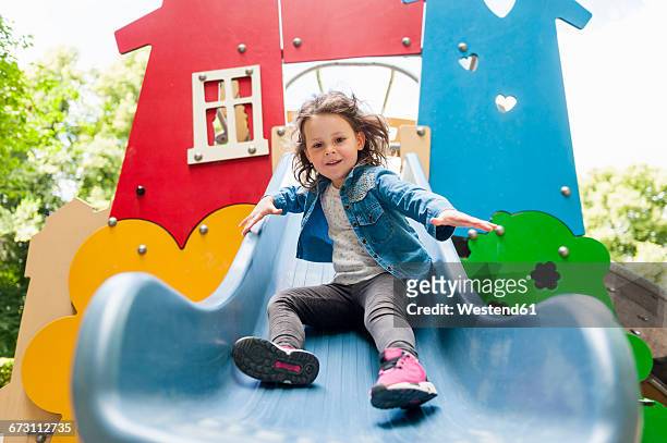 girl on playground slide - kids playground photos et images de collection