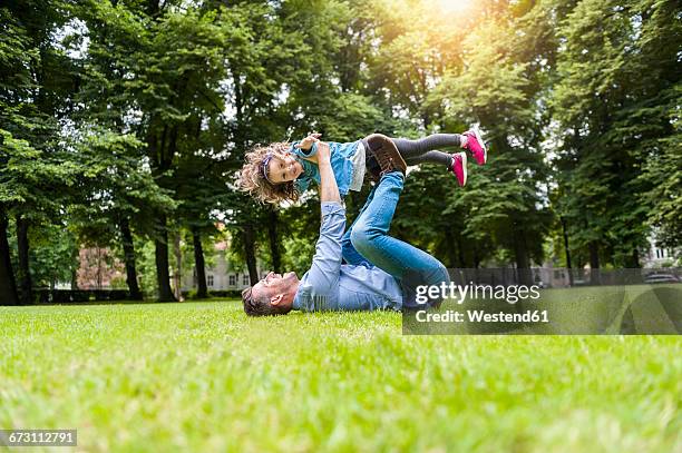father and daughter playing on meadow in park - 飛行機のまね ストックフォトと画像