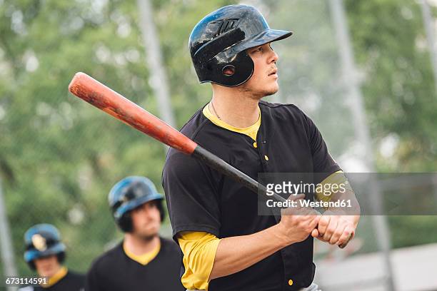 baseball player holding bat - bate fotografías e imágenes de stock