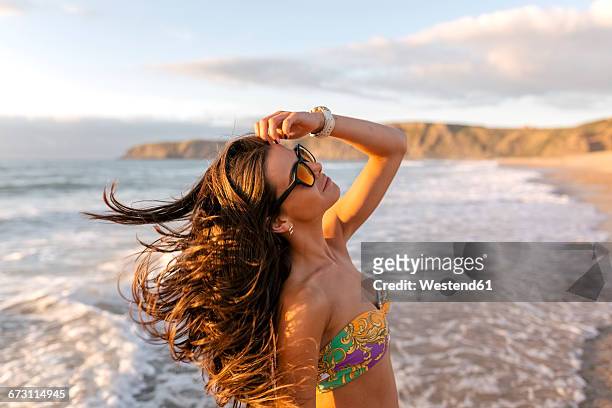 spain, asturias, beautiful young woman on the beach at sunset - capello foto e immagini stock