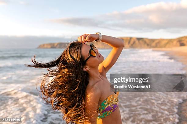 spain, asturias, beautiful young woman on the beach at sunset - hair wind stock pictures, royalty-free photos & images