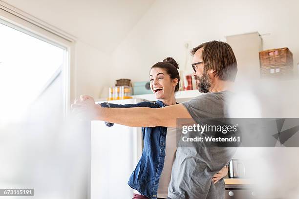 playful couple dancing in kitchen - couple dancing at home stock pictures, royalty-free photos & images